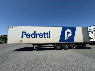 the semi truck is parked in the parking lot near the building