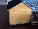 a wooden dog house with a black roof in a store