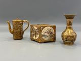 two vases and a teapot sitting next to each other on a table