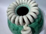 a green vase with a spiral design on it