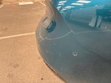 a blue car parked in a parking lot next to a parking meter