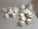 a table with a lot of white dishes and cups