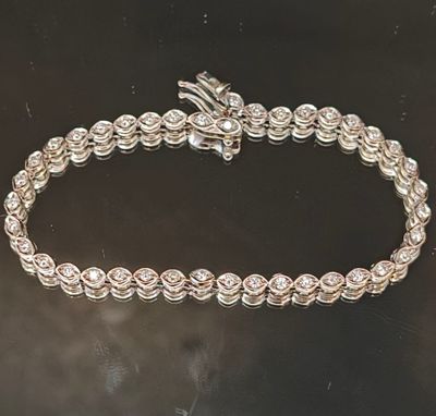 gros plan d'un bracelet en argent sur une surface noire