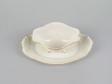 a white and gold plate with a small bowl on top of it
