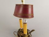 brass table lamp with a red shade and a gold base