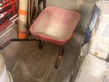 une brouette rouge et une charrette rouge dans un garage