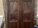 a large wooden armoire in the corner of a room