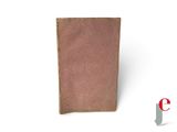 an old book with a brown cover sitting on top of a white surface