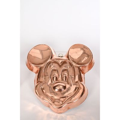 moule à gâteau en forme de tête de Mickey Mouse posé sur un plan de travail blanc