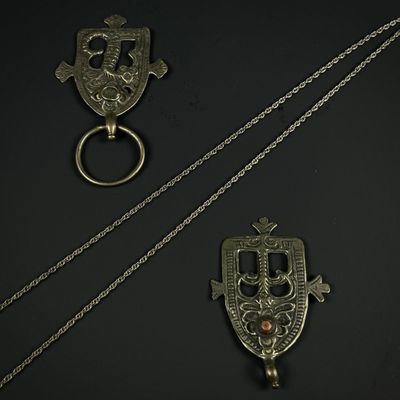 trois bijoux en argent posés sur un fond noir