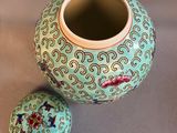 a small vase with a lid sitting on a table