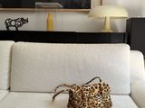 a white couch with a leopard print purse on top of it
