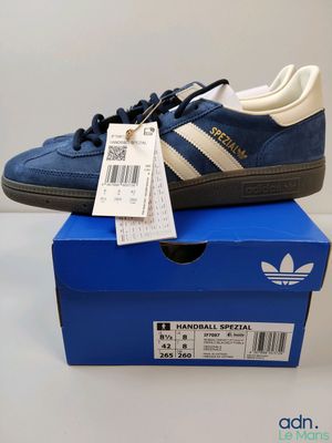 une paire de baskets bleues et blanches posée sur une boîte bleue