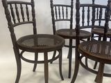 four wooden chairs sitting next to each other on a white surface