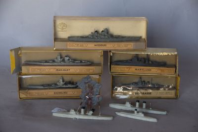 Plusieurs maquettes de bateaux se trouvent dans une boîte posée sur une table