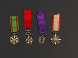 four medals are displayed on a black surface in a row