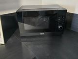 a black microwave sitting on a counter in a kitchen