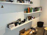 a room with a desk, shelves, and a chair in it