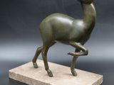 statue of a deer on a marble base on a black background