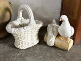 a white bird sitting next to a basket with a bird on it