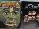 deux livres posés sur une table, sur lesquels sont posés des masques