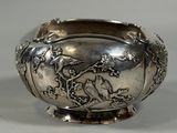 a silver bowl with birds and flowers on it