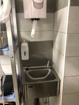 a small bathroom with a sink and a toilet paper dispenser