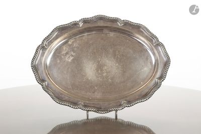 une assiette en argent posée sur un support, sur une table