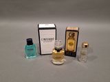 three bottles of perfume sitting next to each other on a table