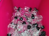 a pink bin full of empty plastic bottles on the floor
