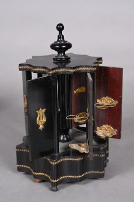 a small black and gold clock on display on a table
