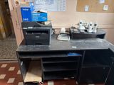 a desk with a printer and a phone on it