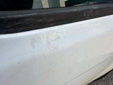 a white car that has a broken door handle on the side of it