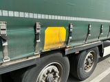 un semi-remorque vert garé sur le bord de la route