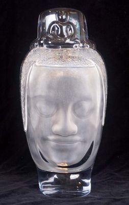 a glass vase with a face on it on a black background