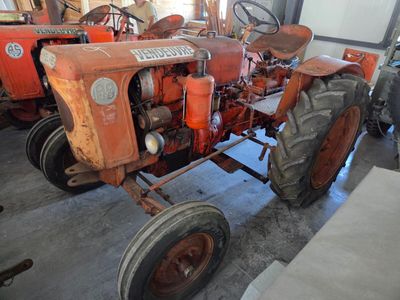 a red tractor that is parked in a garage