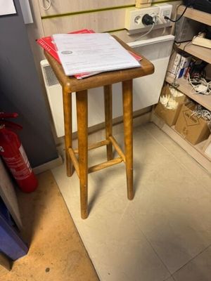 a small wooden stool in the corner of a room