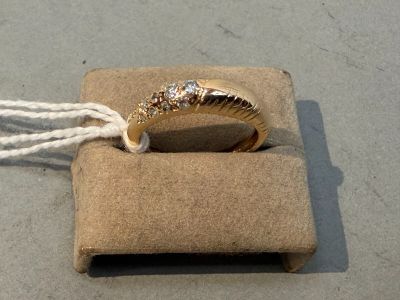 a gold ring with three diamonds in it sitting on a box