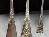 three silver spoons and a silver spoon on a white surface