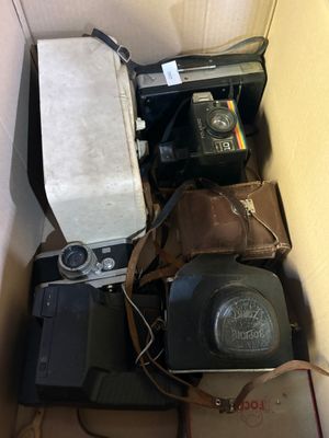 une boîte remplie de vieux appareils photo et d'autres appareils électroniques