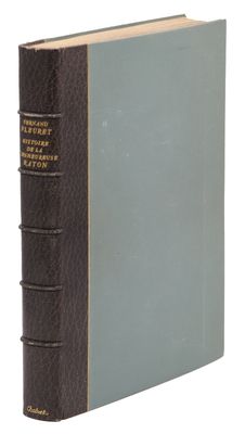 an old book with a blue cover sitting on top of a white surface