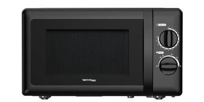 le micro-ondes noir est posé sur un fond blanc, avec un fond blanc
