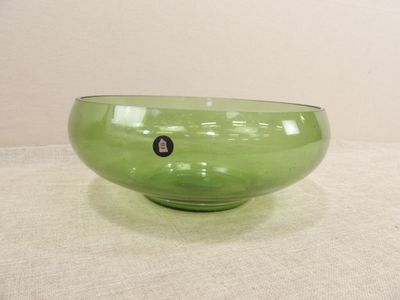 un bol vert posé sur une table recouverte d'une nappe blanche