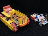 two toy vehicles that are sitting next to each other on a black surface