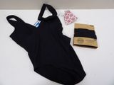 black one piece swimsuit next to a package of underwear on a white surface