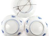 three plates with blue designs on them on a white surface