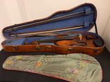 un violon dans son étui, posé sur une table, avec un archet