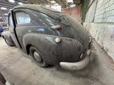 an old car that is sitting in a garage