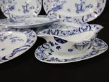 several blue and white plates and saucers on a black table