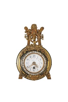 une horloge en or posée sur une surface blanche